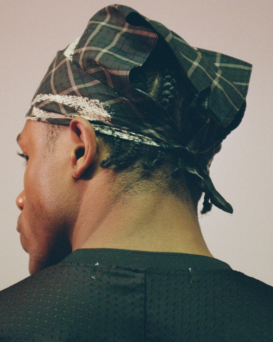 model wearing black bandana scarf around head