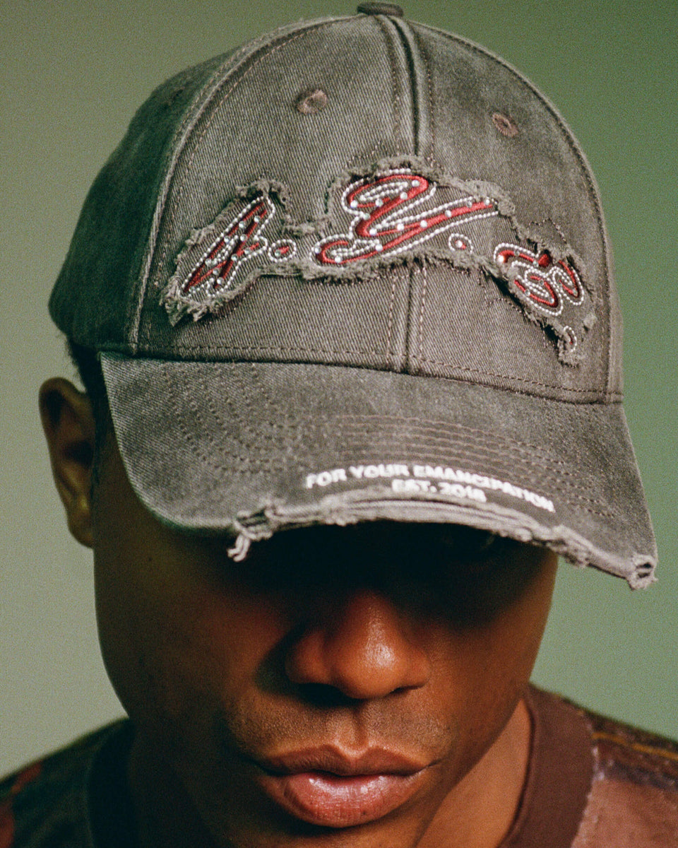 model wearing a hat with branding on a green background