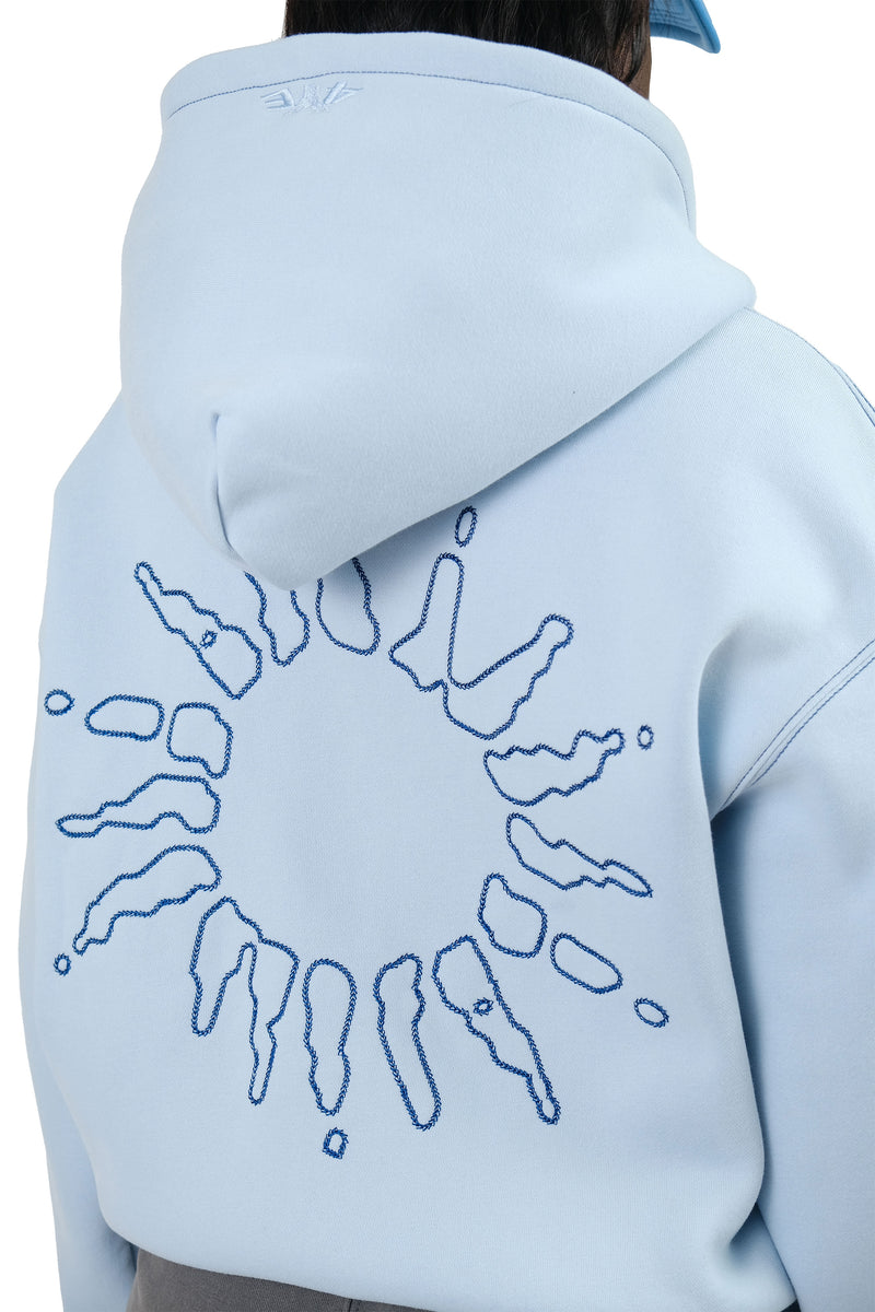 Detailed rear view of a female model wearing the 4YE Signature Logo Zip Hoodie in Light Blue. The hoodie features 325 GSM brushed medium weight fleece offering ultimate comfort and warmth, including high-quality chain stitch embroidery and a 2-way YKK zipper, showcasing a trendy cropped and boxy fit.